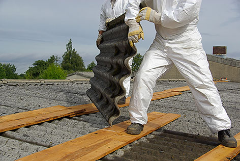 image of asbestos removal specialists removing corrugated roofing made from asbestos containing materials