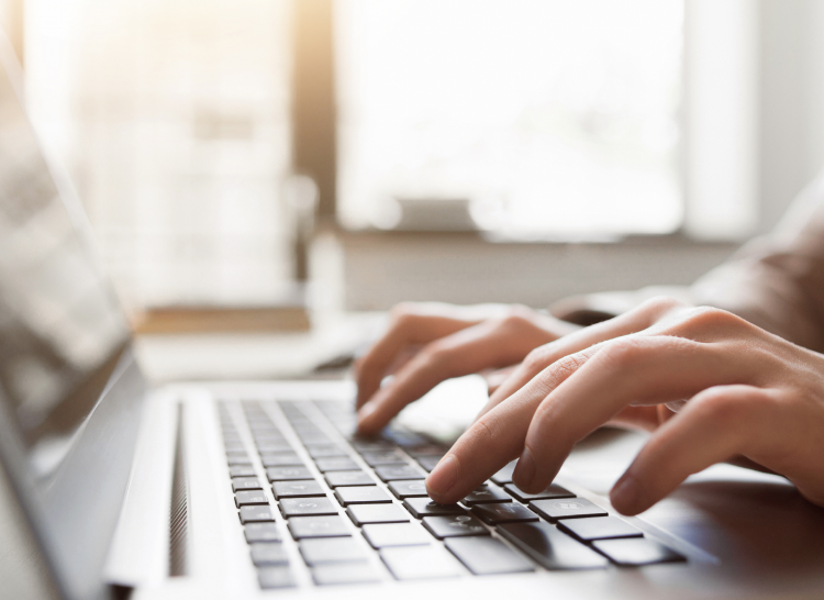 Image of someone typing on a laptop