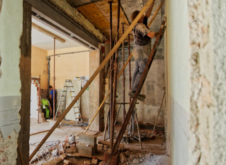 Man on ladder in home undergoing a renovation